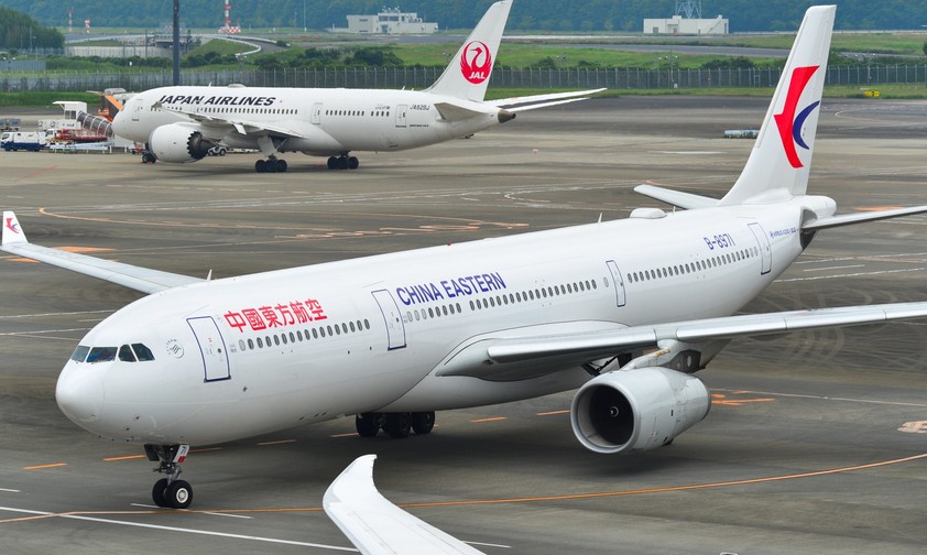Airbus a330 von China Eastern im Hintergrund steht ein Flugzeug von Japan Airlines: Chinesische Airlines erleben derzeit eine Stornierungswelle für Japan-Flüge.