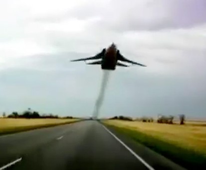 Ziemlich tief fliegt diese SU-24 über der Straße.
