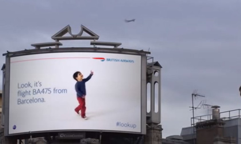 Riesenbaby zeigt auf kleines Flugzeug: Süß oder unheimlich?