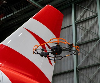 Die Drohne neben dem Heck eins Airbus-Jets von Austrian Airlines. Sie nimmt jede Sekunde ein hochauflösendes ...