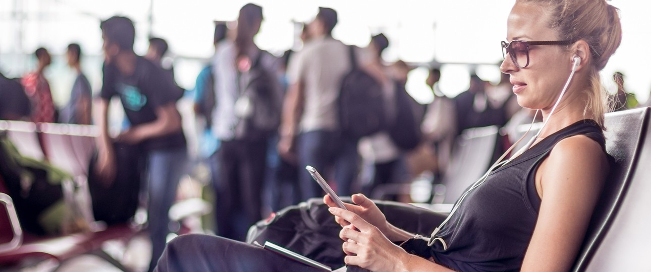 Frau mit Mobiltelefon am Flughafen: Das Wifi ist oft ein Grund für Ärger.