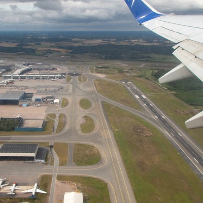 Blick auf eine Flughafen aus der Luft: Piste, Rollwege und Vorfeld.