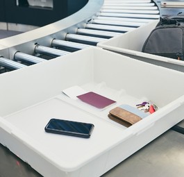 Smartphone in der Plastikwanne: In den USA derzeit nicht erwünscht.