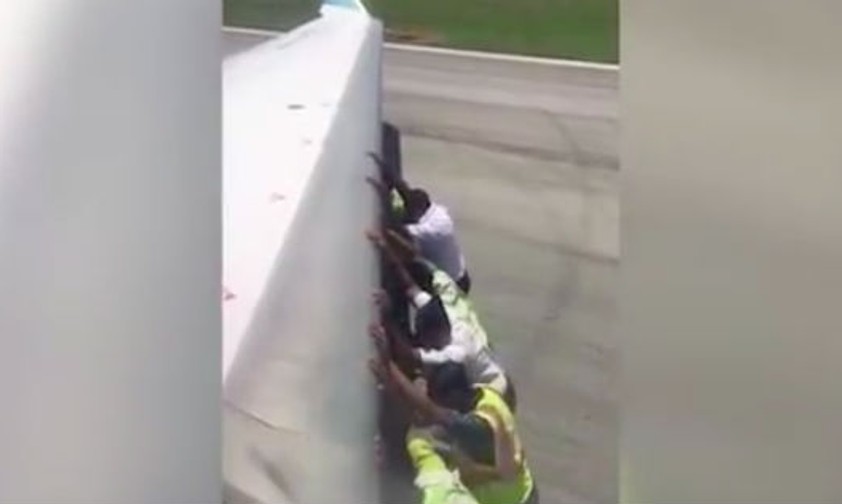 Personal schiebt einen Jet aus misslicher Lage weg