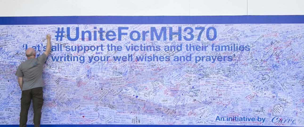Hoffen und beten: Ein Mann in Kuala Lumpur schreibt an eine Gedenkwand für die Opfer von Flug MH370.