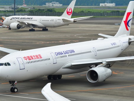 Airbus a330 von China Eastern im Hintergrund steht ein Flugzeug von Japan Airlines: Chinesische Airlines erleben derzeit eine Stornierungswelle für Japan-Flüge.