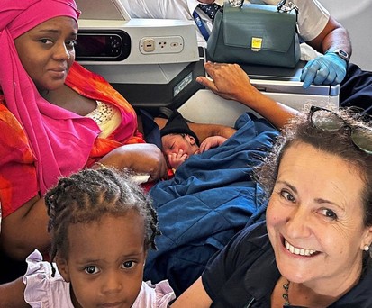 Frischgebackene Mutter mit ihren Baby und den Helfenden an Bord des A330-200.