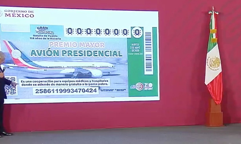 Andrés Manuel López Obrador presents the raffle ticket.