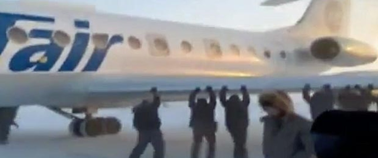 Passagiere packen mit an: Die Tu-134 wurde aus dem Eis befreit.