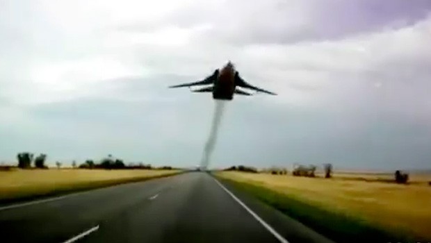 Ziemlich tief fliegt diese SU-24 über der Straße.