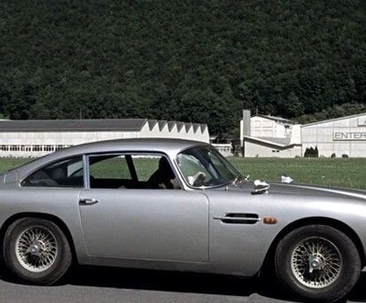 James Bond und sein Aston Martin vor der Goldschmelze von Auric Goldfinger.
