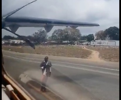 Der Mann tanzt vor einem startenden Flugzeug.