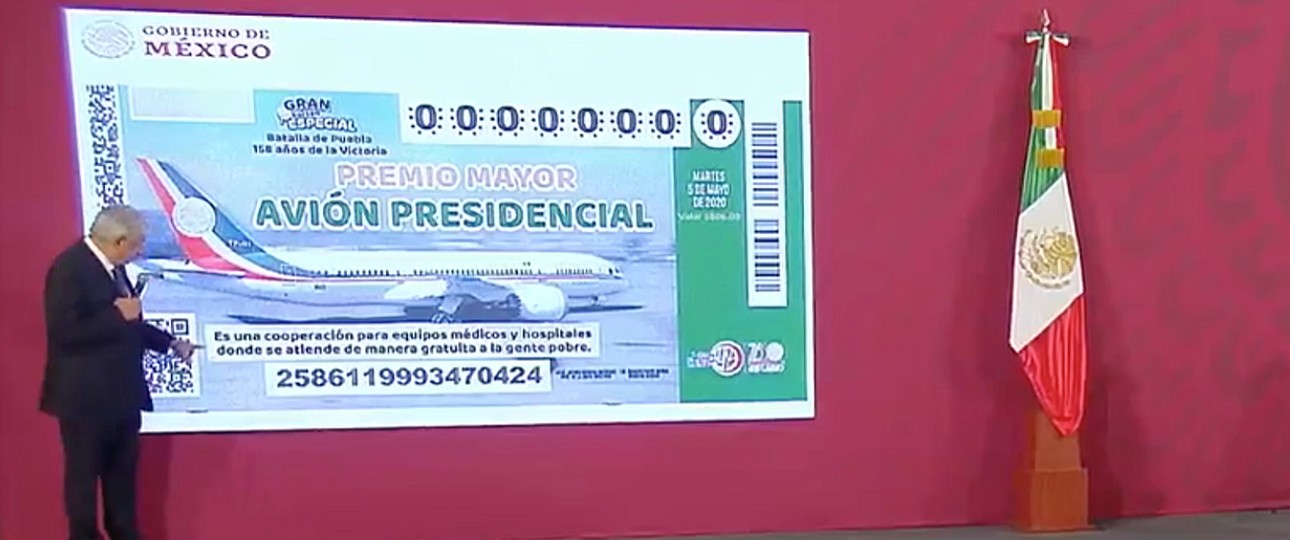 Andrés Manuel López Obrador presents the raffle ticket.