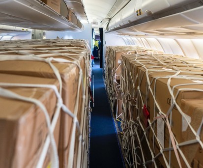 Provisorische Frachtkabine in einem Passagierflieger: Kartons statt Sitze.