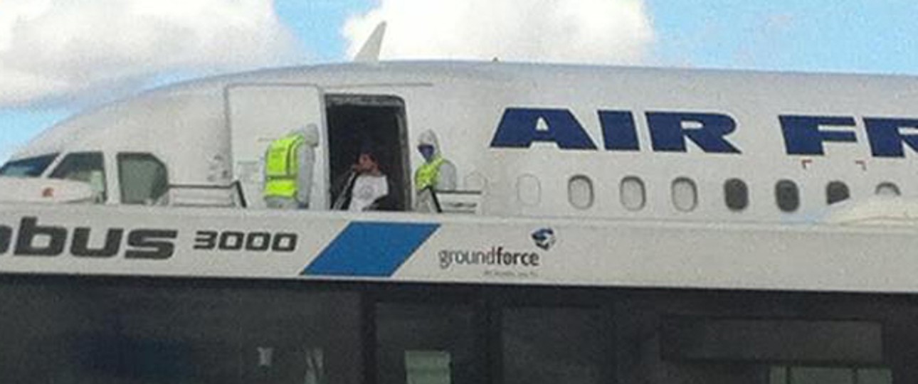 Männer mit Schutzanzügen vor dem Flugzeug: Noch hat sich der Verdacht nicht bestätigt.