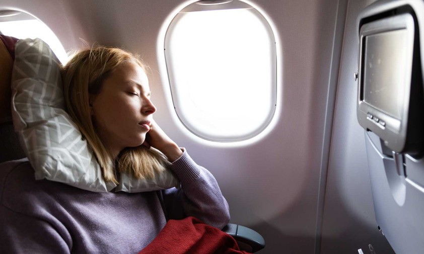 Eine Reisende schläft während des Fluges: Die App Timeshifter soll Jetlag reduzieren.