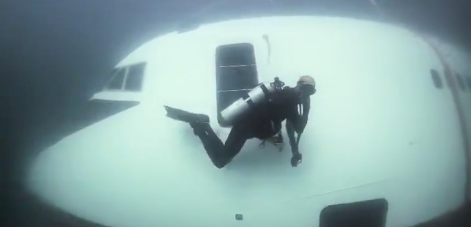 Nachdem Versenken sichern Taucher das Flugzeug ab, welches auch ein künstliches Korallenriff werden soll.