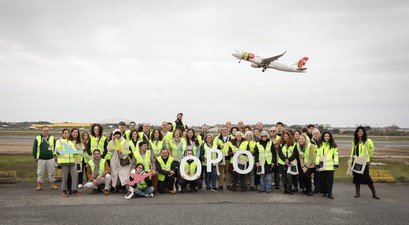 Mitarbeitende am Flughafen Porto: Im Hintergrund ein Flugzeug von Tap.