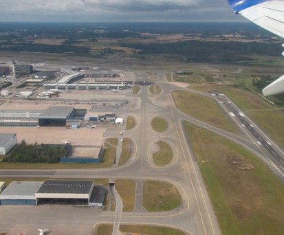 Blick auf eine Flughafen aus der Luft: Piste, Rollwege und Vorfeld.