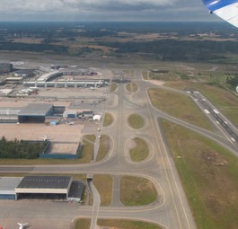 Blick auf eine Flughafen aus der Luft: Piste, Rollwege und Vorfeld.