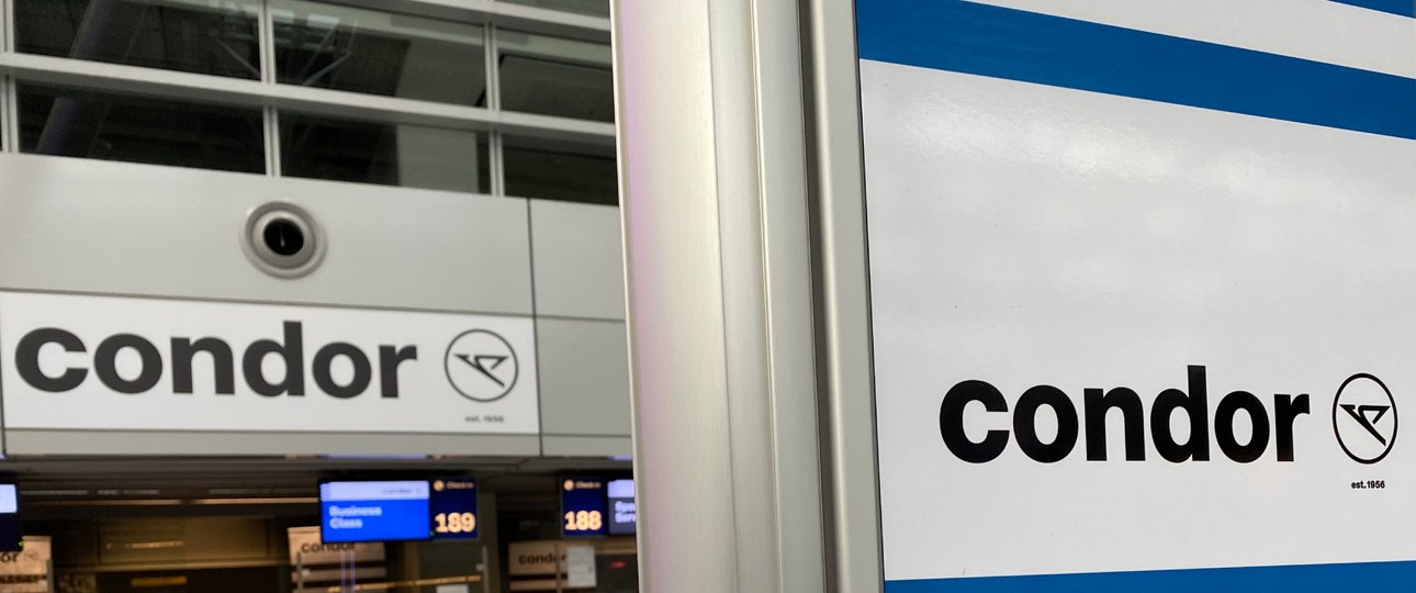 Condor-Schalter und -Schild: Kostenfreier Vorabend-Check-in dank Abo.