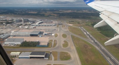 Blick auf eine Flughafen aus der Luft: Piste, Rollwege und Vorfeld.
