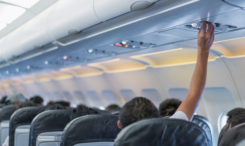 Ein Mann regelt die Luftzufuhr an seinem Sitz: Heiße Flugzeugkabinen werden zunehmend zum Problem.