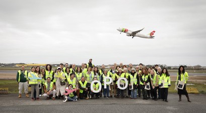 Mitarbeitende am Flughafen Porto: Im Hintergrund ein Flugzeug von Tap.