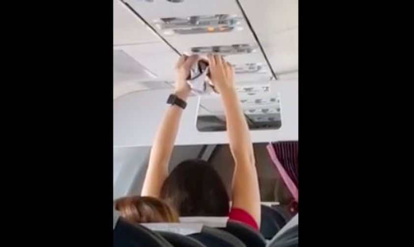 Frau trocknet Unterhose mit der Flugzeuglüftung