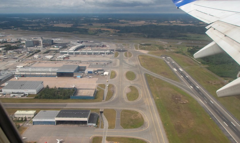 Blick auf eine Flughafen aus der Luft: Piste, Rollwege und Vorfeld.