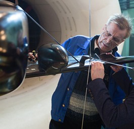 Forscher des Tsagi schauen sich ein Modell des neuen Fliegers an. Sie ...