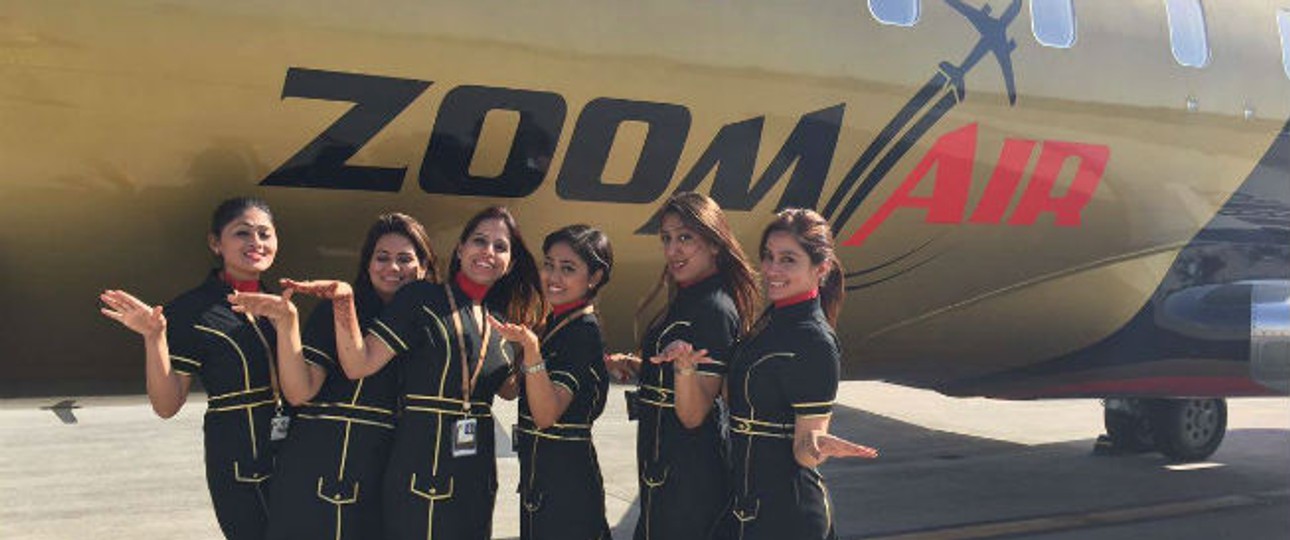 Flugbegleiterinnen von Zoom Air vor einem Flugzeug: Die Fluggesellschaft plant mit einem Wachstum von 20 Prozent pro Jahr.