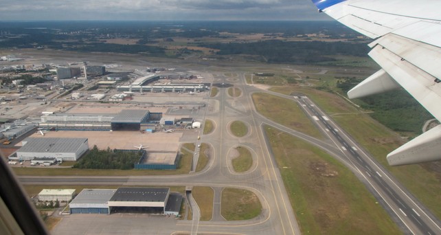Blick auf eine Flughafen aus der Luft: Piste, Rollwege und Vorfeld.
