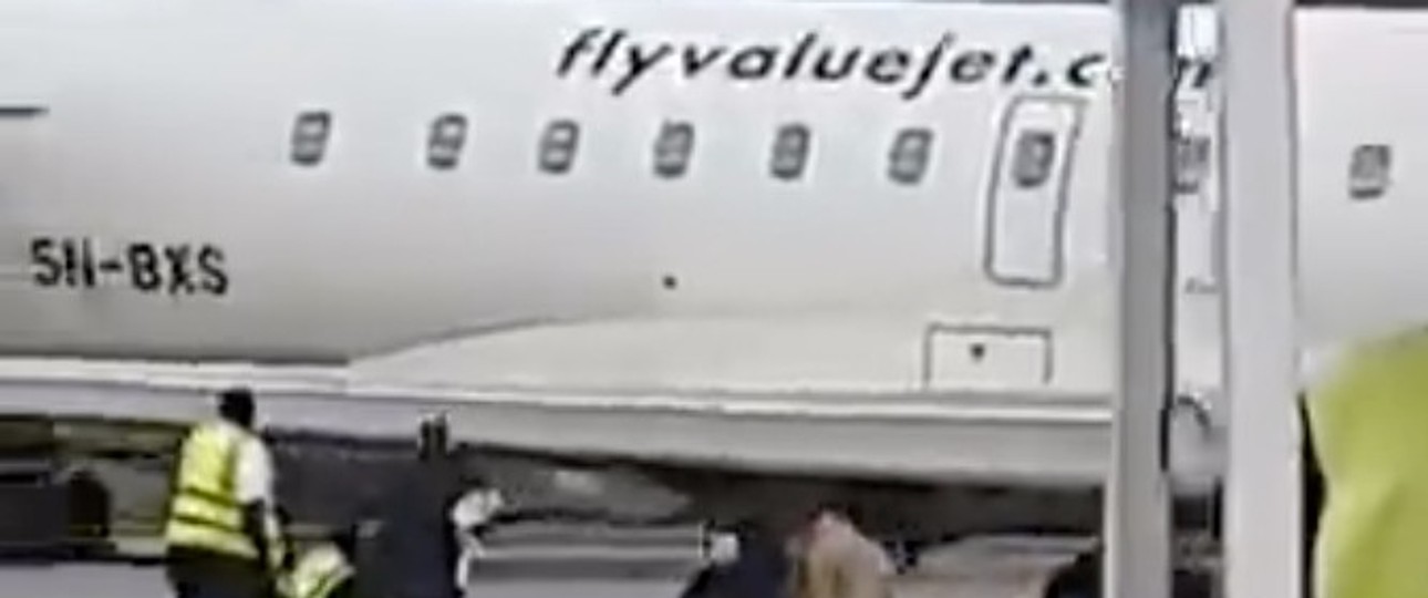Dem Flügel der CRJ900 ausweichen: Personen ducken sich zu Boden.