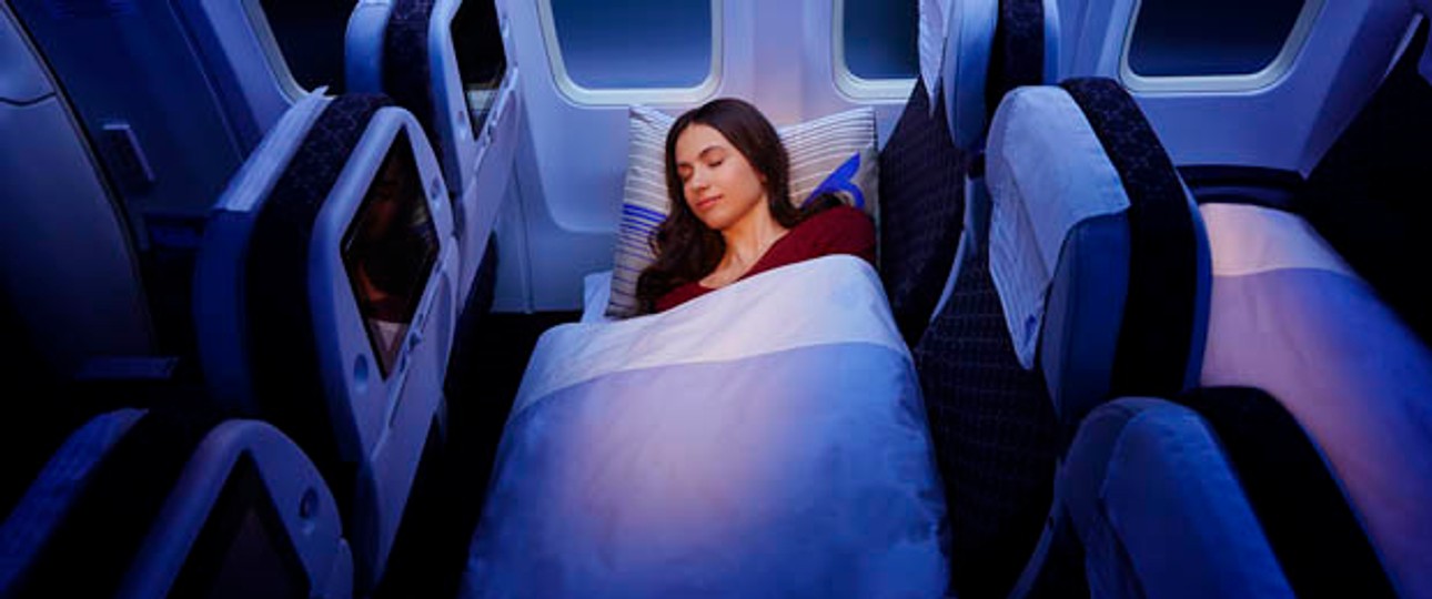 Schlaf in der Economy-Sleeper-Klasse: Drei Sitze, Matratze, Decke und Kissen.