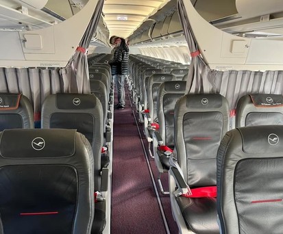 Rote Gurte, Trachten-Vorhanghalter: So sieht es im Airbus A319 von Lufthansa Cityline aus.