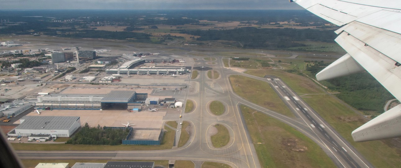 Blick auf eine Flughafen aus der Luft: Piste, Rollwege und Vorfeld.