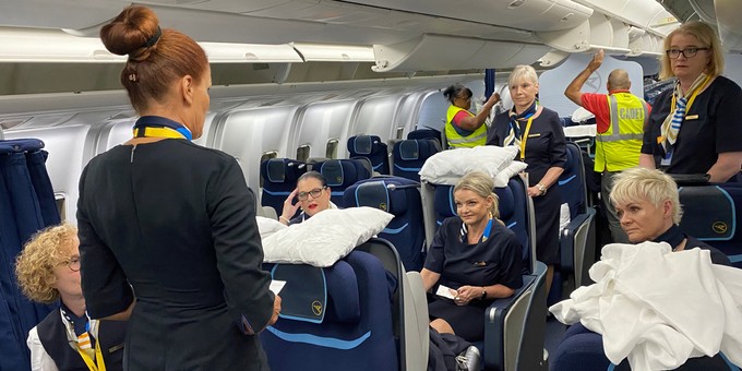 Purserin Karin Hohl spricht mit ihrer Crew, während die Kabine für den Flug hergerichtet wird.