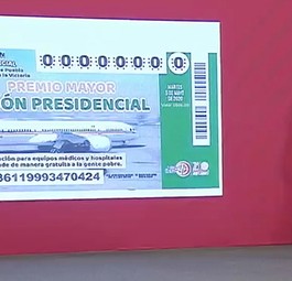 Andrés Manuel López Obrador presents the raffle ticket.