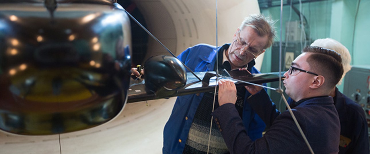 Forscher des Tsagi schauen sich ein Modell des neuen Fliegers an. Sie ...