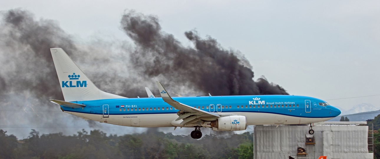Eine Maschine von KLM fliegt am brennenden Gebäude ...