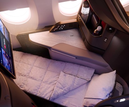 Ein Sitz der Delta One Suite im A350-1000 als Bettmodus mit Decke
