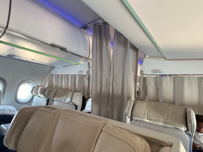 Die Premium Economy ist mit Vorhängen abgetrennt.