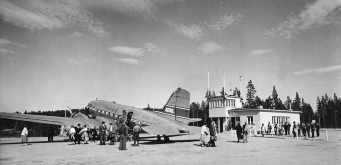 Passagiere auf dem Flughafen Ivalo in den 1960er-Jahren. Das abgebildete Flugzeug ist die Douglas DC-3 OH-LCD.