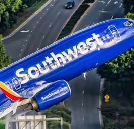 Boeing 737-800 von Kapitän Ted Orris beim Abschiedsflug: Die Aufnahme wurde aus einem Hubschrauber fotografiert, in die Kamera winkt Orris' Kopilot.