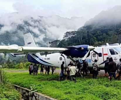 Bewohner ziehen Twin Otter mit Seil aus Morast