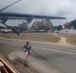 Der Mann tanzt vor einem startenden Flugzeug.