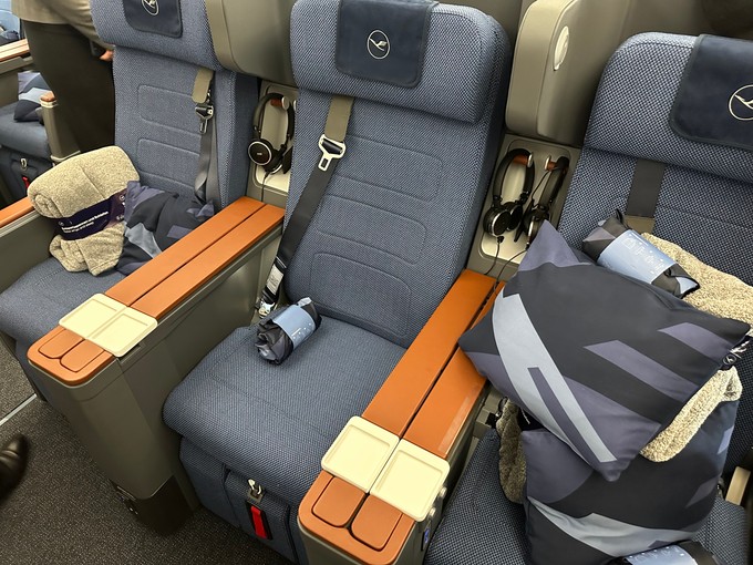 Die Premium Economy hat bei Lufthansa ein deutliches Upgrade erhalten. Die Sitze sehen edel aus, bieten viel Platz und 4K-Bildschirme. Sie stammen vom Anbieter Zim - wie die bei Swiss. Hier gibt es ebenfalls ein Amenity-Kit, eine kuschelige Decke und Kissen.