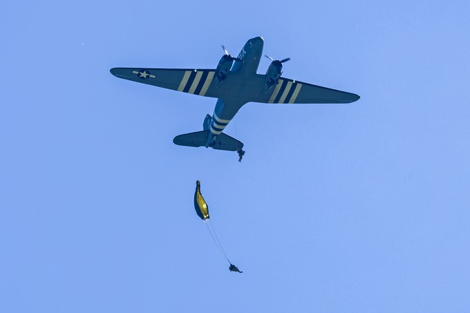 Ein Fallschirmspringer springt aus ihr heraus.