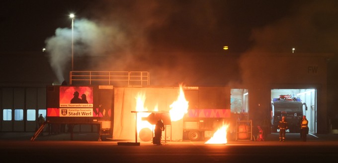 Notfallübung am Flughafen Dortmund: Feuerwehrleute zünden eine Triebwerksattrappe an.